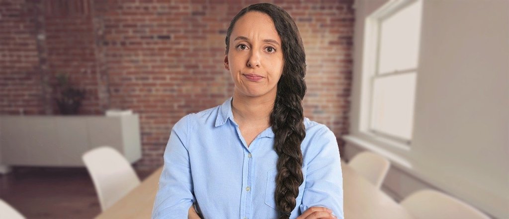Frustrated Woman in front of table, chairs, and brick wall